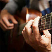 Der Gitarrist Jon Gomm lässt seine Finger nur so über die Gitarre gleiten, sodass eine Band erklingt 