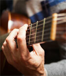 Der Gitarrist Jon Gomm lässt seine Finger nur so über die Gitarre gleiten, sodass eine Band erklingt 